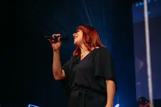 Sängerin singt während des Worships auf der Bühne