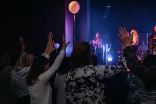 Frauen heben während des Worships ihre Hände